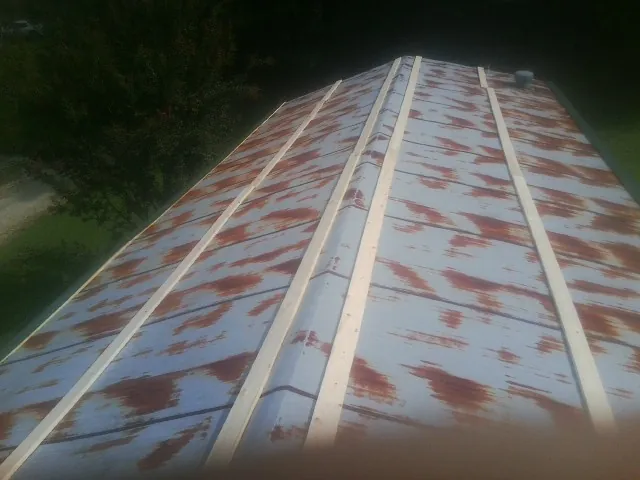 Rusted metal roof panels with new wood purlins before replacement — Storm Damage Roof Repair in Dixie by Roofing Brothers